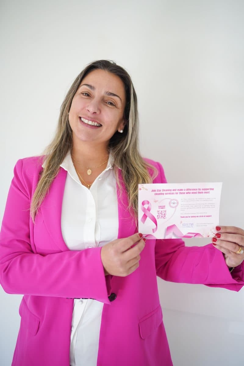 Mariana, owner of Star Cleaning SC, holding a Cleaning for a Reason charity card