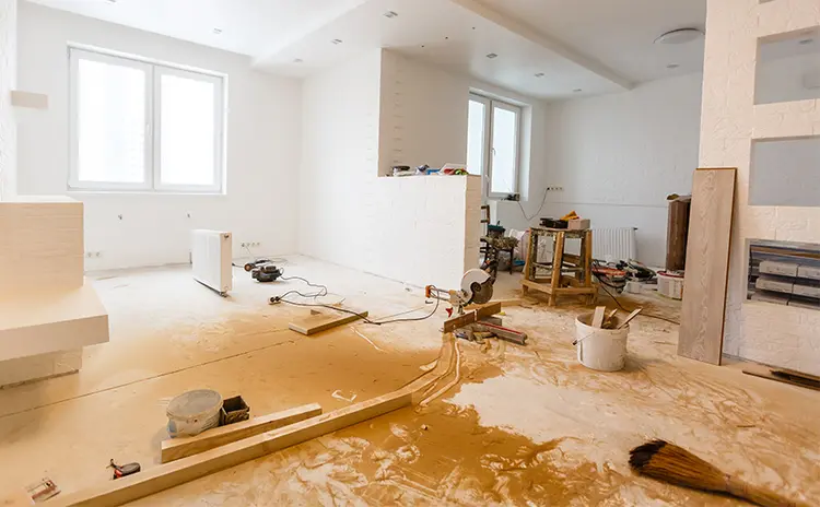 Room mid-renovation with construction dust and debris on the floor